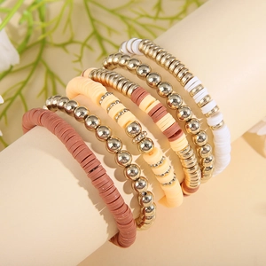 Detail of 5-piece bohemian layered bracelets with coffee clay heishi beads and gold metal beads