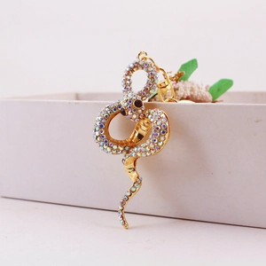 Creative gold snake keychain with colorful rhinestones on a white gift box display
