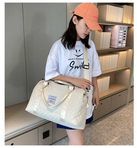 Quilted cream travel bag worn by model featuring adjustable strap and spacious design