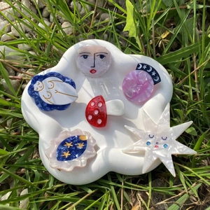 Detailed view of colorful acetate mushroom and star hair clips on a ceramic tray