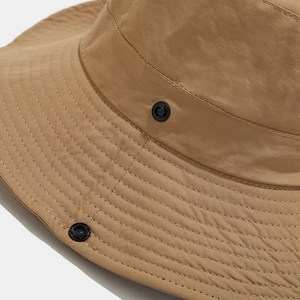 Dettaglio del cappello da sole kaki con cuciture precise e bottone a pressione in metallo