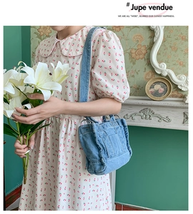 Detail of blue washed denim tote bag with wavy ruffle edges and wide shoulder strap