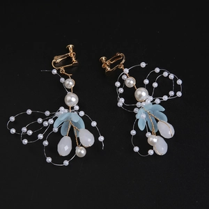 Detail of gold leaf earrings with blue frosted petals and teardrop pearls