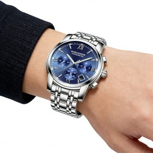Close-up detail of men's stainless steel watch featuring a blue dial and date window.