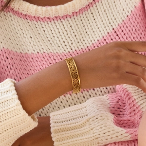 Détail d'un bracelet ouvert en acier inoxydable doré 18 carats avec dentelle gravée