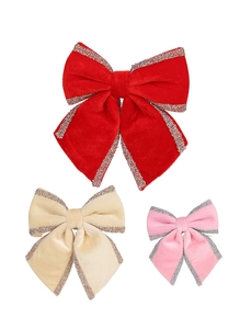 Detailed view of red, champagne and pink velvet Christmas bows with glitter edges