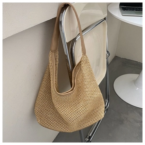 Detail of hollow mesh woven beach bag with PU leather strap on a chair