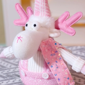 Dettaglio di renna di peluche con paillettes rosa e cappello lavorato a maglia per Natale
