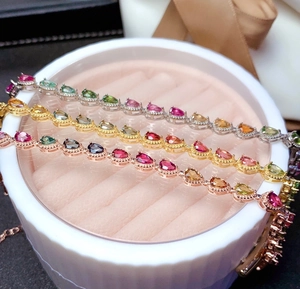 Three colorful teardrop gemstone bracelets in silver, gold, and rose gold finishes