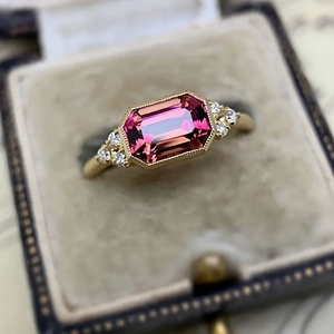 Vintage gold engagement ring with emerald cut pink gemstone and diamond accents