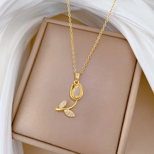 Macro shot of gold tulip pendant necklace with cat eye stone and crystal inlay details