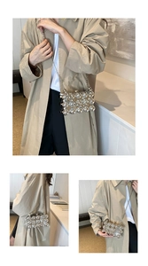 Detail of silver beaded sphere evening bag with metal chain strap worn on beige coat