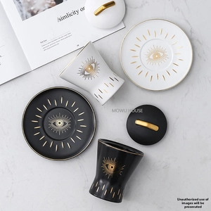 Ceramic seasoning jar set with evil eye pattern and gold lids on marble background