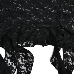 Gros plan sur la dentelle florale noire et le détail de l'ourlet à volants de la robe