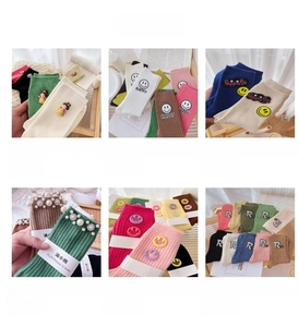 Détails de chaussettes en coton colorées avec motifs smiley et écussons lettrés