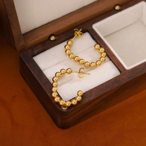Elegant 18K gold plated stainless steel beaded C-shaped hoop earrings on a wooden jewelry box