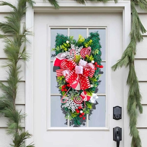 Christmas upside down tree decoration with red bows and candy canes on a white door