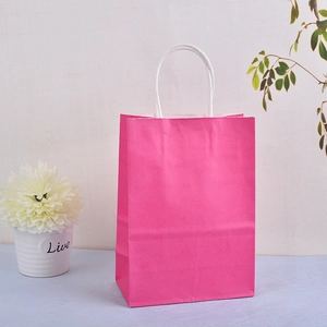 Close-up of pink kraft paper gift bag with durable white twisted rope handles detail