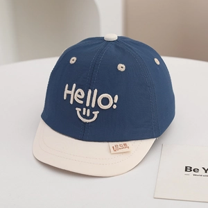 Detail of baby baseball cap with Hello embroidery and blue contrast design texture
