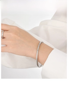 Detail of a minimalist 4mm solid silver bangle and matching slim ring on model