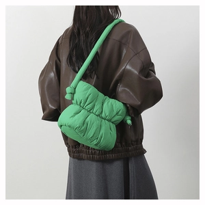 Detail shot of a bright green puffy cloud bag with knotted nylon shoulder strap