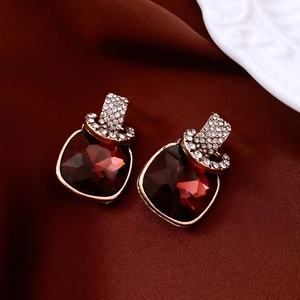 Macro shot of vintage dark red square crystal earrings with pavé diamond gold fasteners