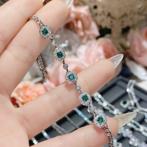Macro shot of S925 silver bracelet with green emerald zircon and halo diamond setting
