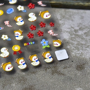 Macro shot of 5D embossed nail art stickers with cute 3D yellow ducks and colorful flowers