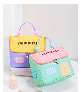 Detail of color-block cosmetic bags featuring beaded handles and house-shaped design