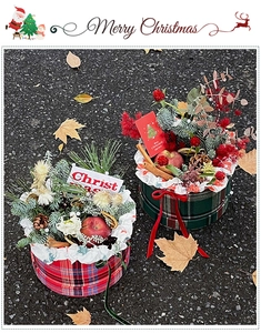 Detail of round Christmas gift boxes featuring red apples, pine cones and plaid fabric