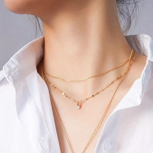 Close-up of layered 18K gold plated titanium necklace with zircon pendant on model