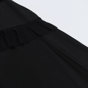 Détail des volants et de la fente latérale sur cette robe d'été noire élégante