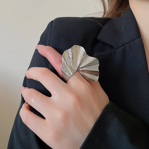 Detailed view of silver statement ring with ginkgo leaf textures on a model