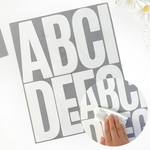 Detail shot of large white waterproof alphabet stickers showing easy water cleaning feature