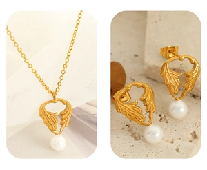 Detailed set of gold necklace and earrings with metallic leaf design and pearls