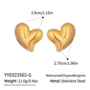 Detail view of puffy gold heart earrings with size measurements in stainless steel
