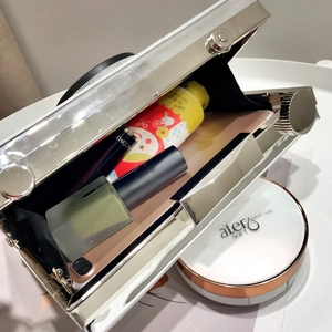 Vue de dessus d'un sac caméra argenté montrant l'espace pour téléphone et maquillage
