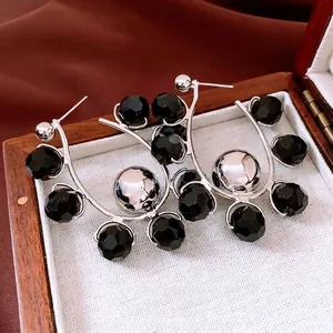 Chic silver-tone C-shape hoop earrings featuring black faceted beads and polished metal spheres