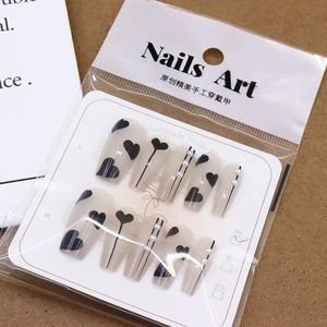 Faux ongles faits main, base translucide mate avec motifs cœurs noirs et perles