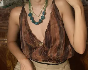 Detail of a vintage layered acrylic necklace with blue and green beads on a female model