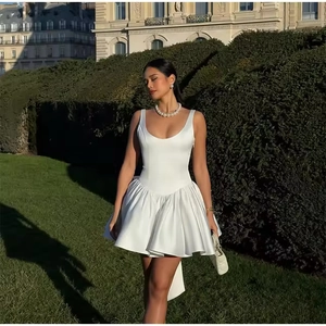 Détail d'une robe de soirée mini en satin blanc à épaules dénudées et jupe plissée