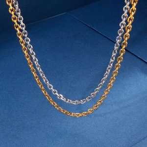 Minimalist stainless steel O-chain necklaces in gold and silver hanging on dark blue background