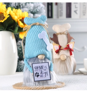 Close-up of knitted Christmas gnomes with faux fur beards and home decor props