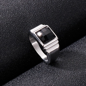 Detailed view of men's silver steel ring with square black gemstone on black leather