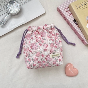 Detailed view of quilted cotton drawstring bag with pink floral and rabbit patterns