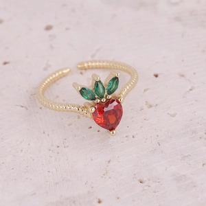 Detailed macro view of strawberry ring featuring red heart cubic zirconia and green leaves