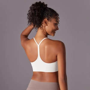 Detailed back view of white sports bra with slim T-back straps and brushed fabric texture
