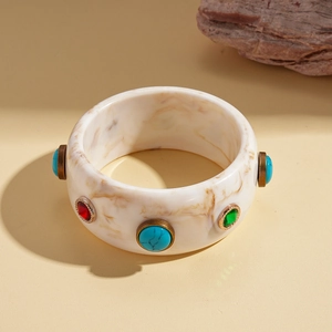 Macro detail of marble resin bangle with multicolored stones and bronze frames