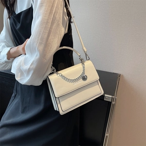 White PU leather crossbody bag with silver chain and top handle on a fashion model