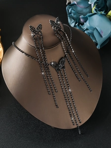 Macro shot of black rhinestone butterfly long tassel necklace and earring jewelry set on model